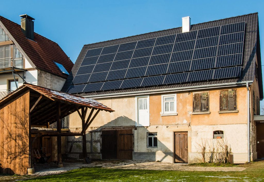 Technicians fitting discreet solar modules along an old sloping roof